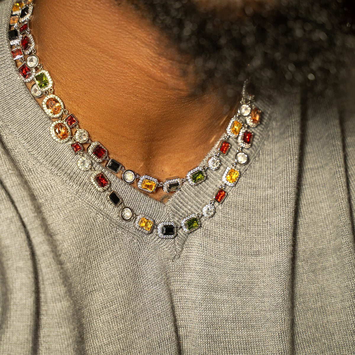 HAYES CARROLL 10mm silver necklace featuring multi-colored precision-cut gemstones worn on a model in a grey sweater